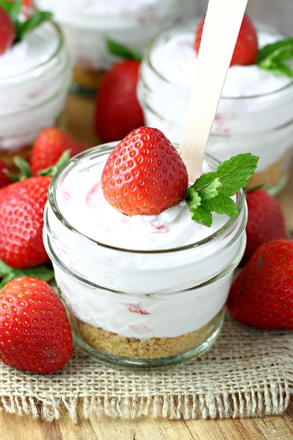 Mason Jar Strawberry Frozen Yogurt Cheesecakes: cool and creamy strawberry frozen yogurt cheesecake served in Mason jars. With warm weather just around the corner (if it hasn't arrived already), it's great to have some no-bake dessert recipes up your sleeve. These Mason Jar Strawberry Frozen Yogurt Cheesecakes are the perfect way to welcome summer!